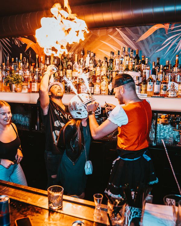 Barman zapaluje cocktail u baru